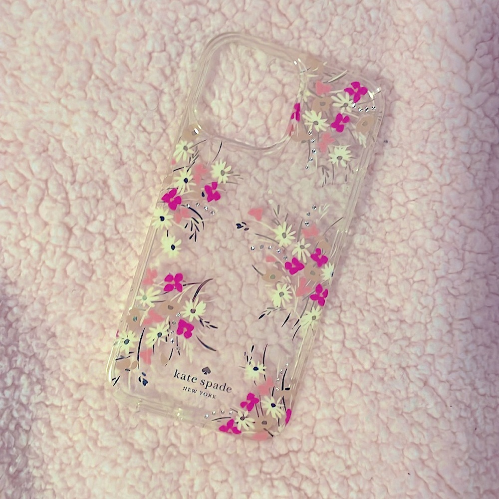 A Kate spade phone case with pink purple and white flowers with Crystals.